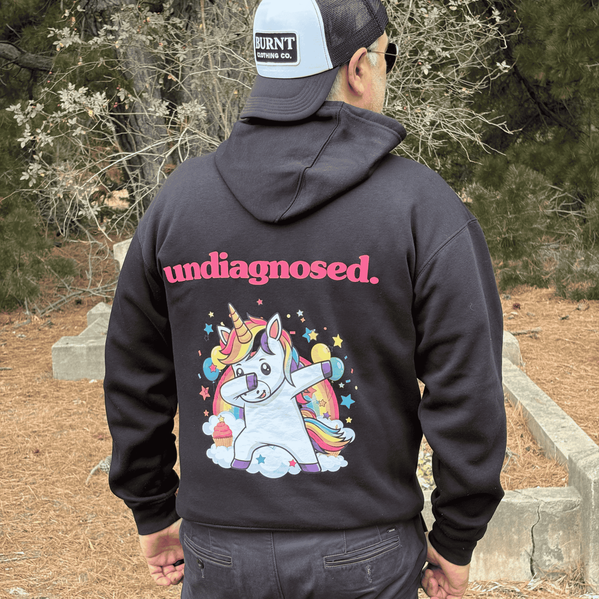 Black undiagnosed. Unicorn hoodie with full-colour back graphic and pink lettering.