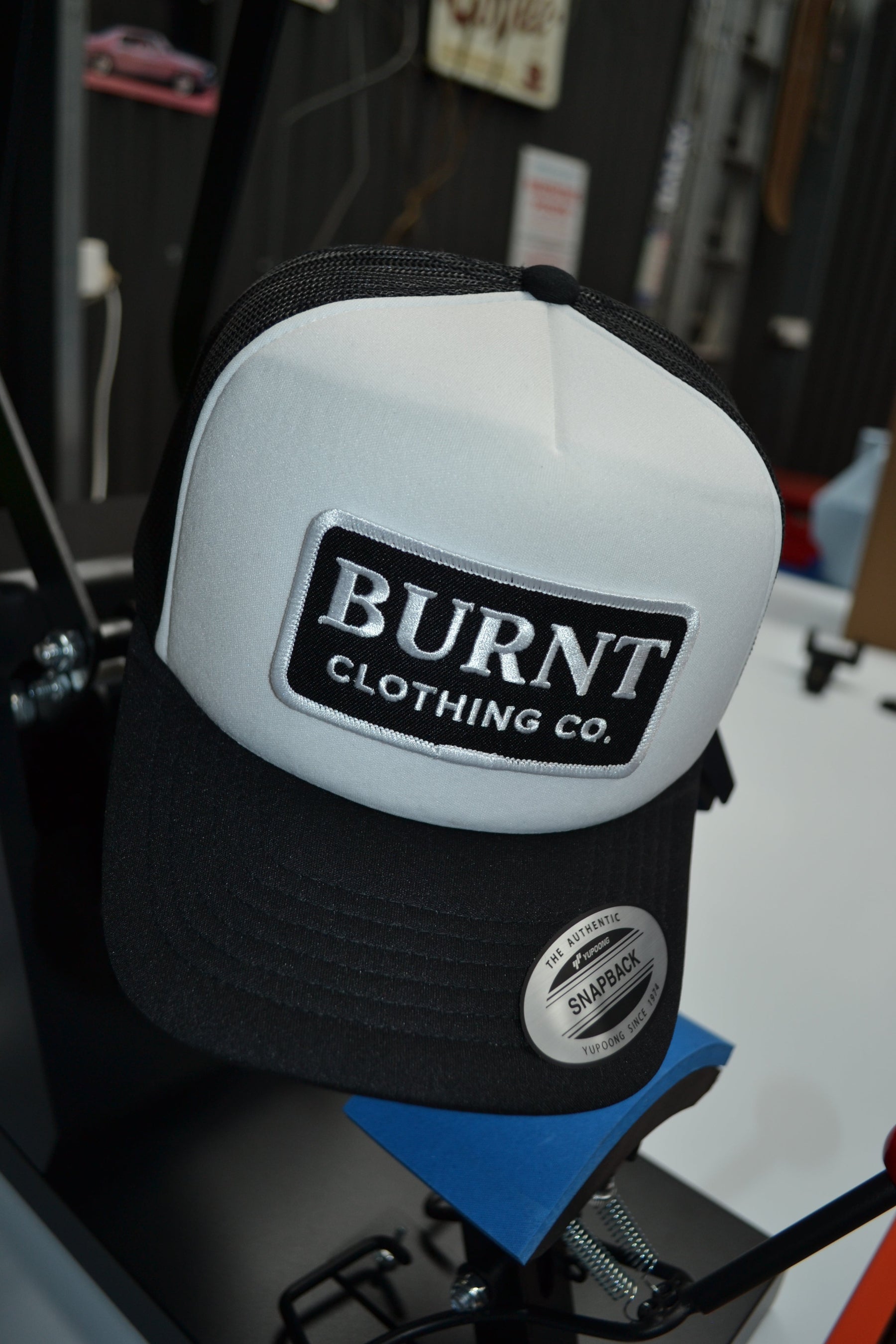 White boxing glove with 'Burnt Clothing Co.' logo on a blurred background