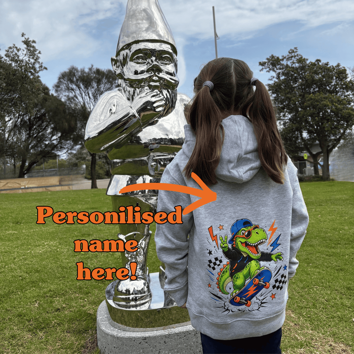 Child wearing grey Dino Skater kids hoodie showing personalised name placement