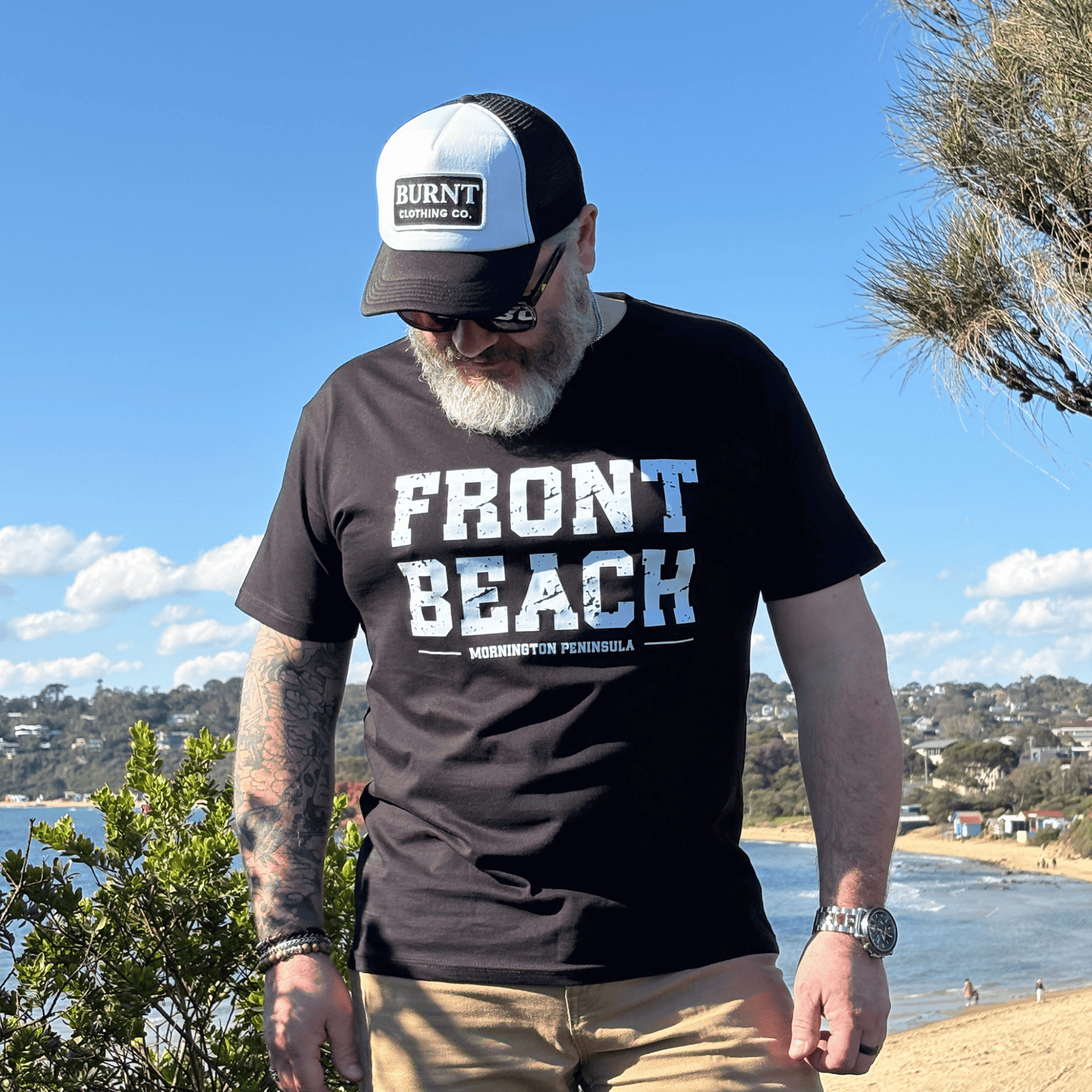 Man wearing the black Front Beach tee at a Mornington Peninsula coastal lookout