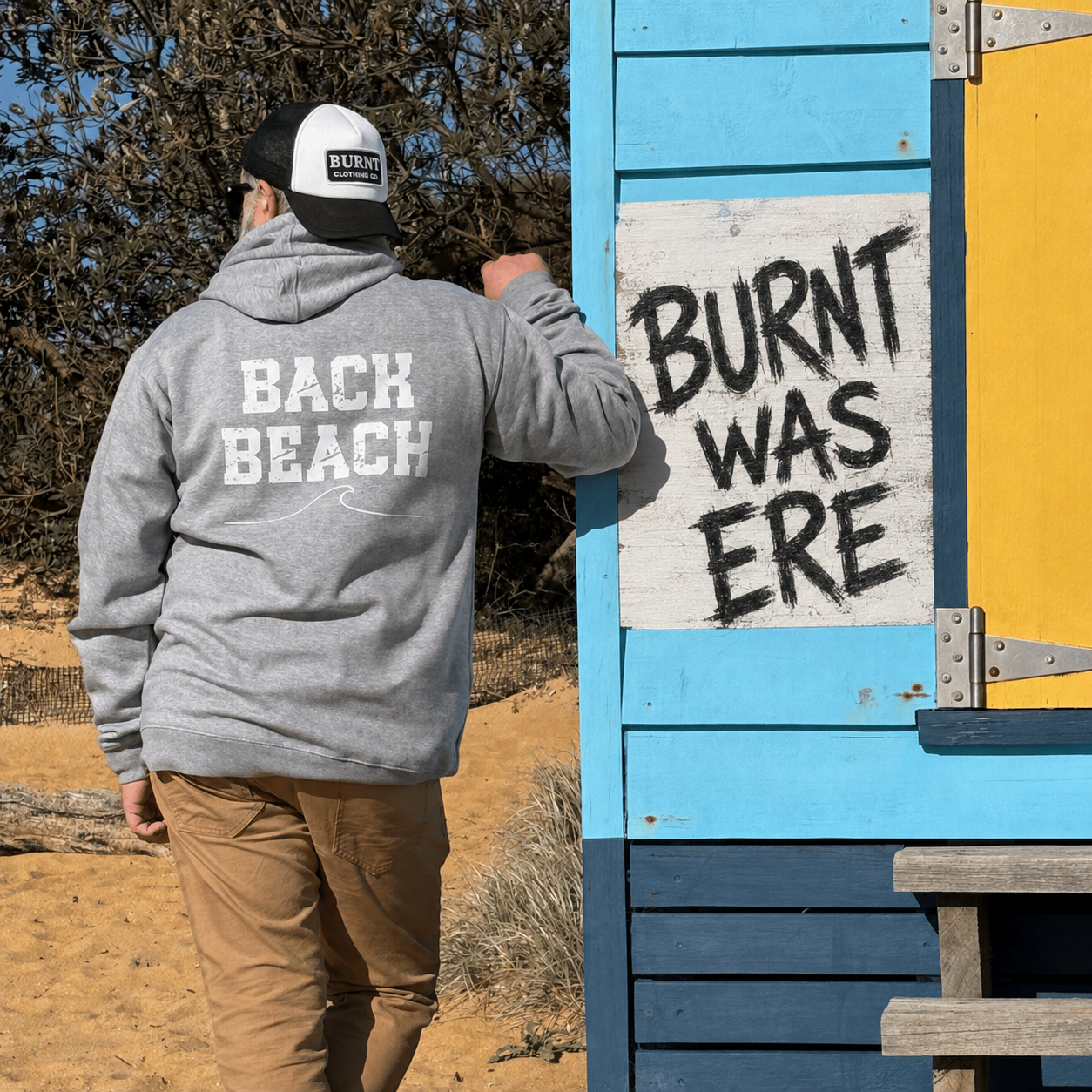 Rear view of the grey marle hoodie showing the Back Beach wave print beside a colourful beach box