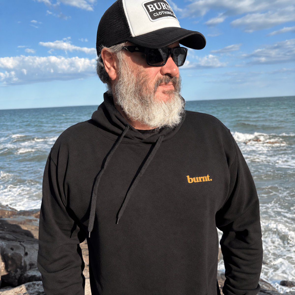 Front view of a black Not for Normal hoodie with a small BURNT chest print.