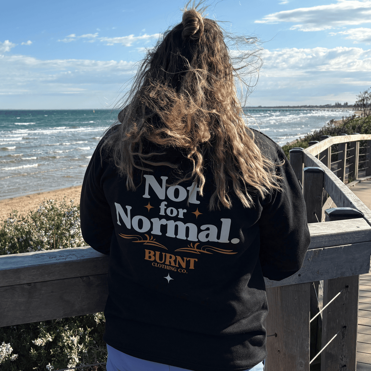 Black Old School hoodie featuring a small BURNT chest print and cream serif back design.