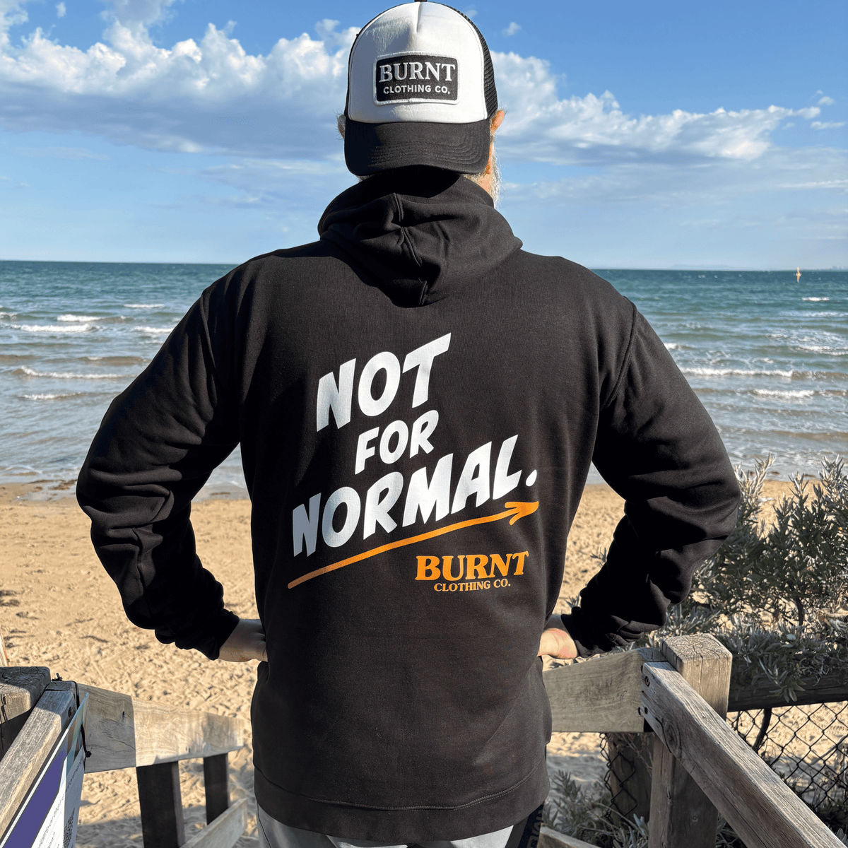 Black Statement hoodie with bold white and burnt-orange NOT FOR NORMAL back print.