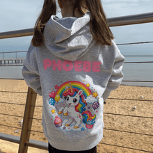 Child wearing grey Cupcake Unicorn personalised kids hoodie with pink name on back