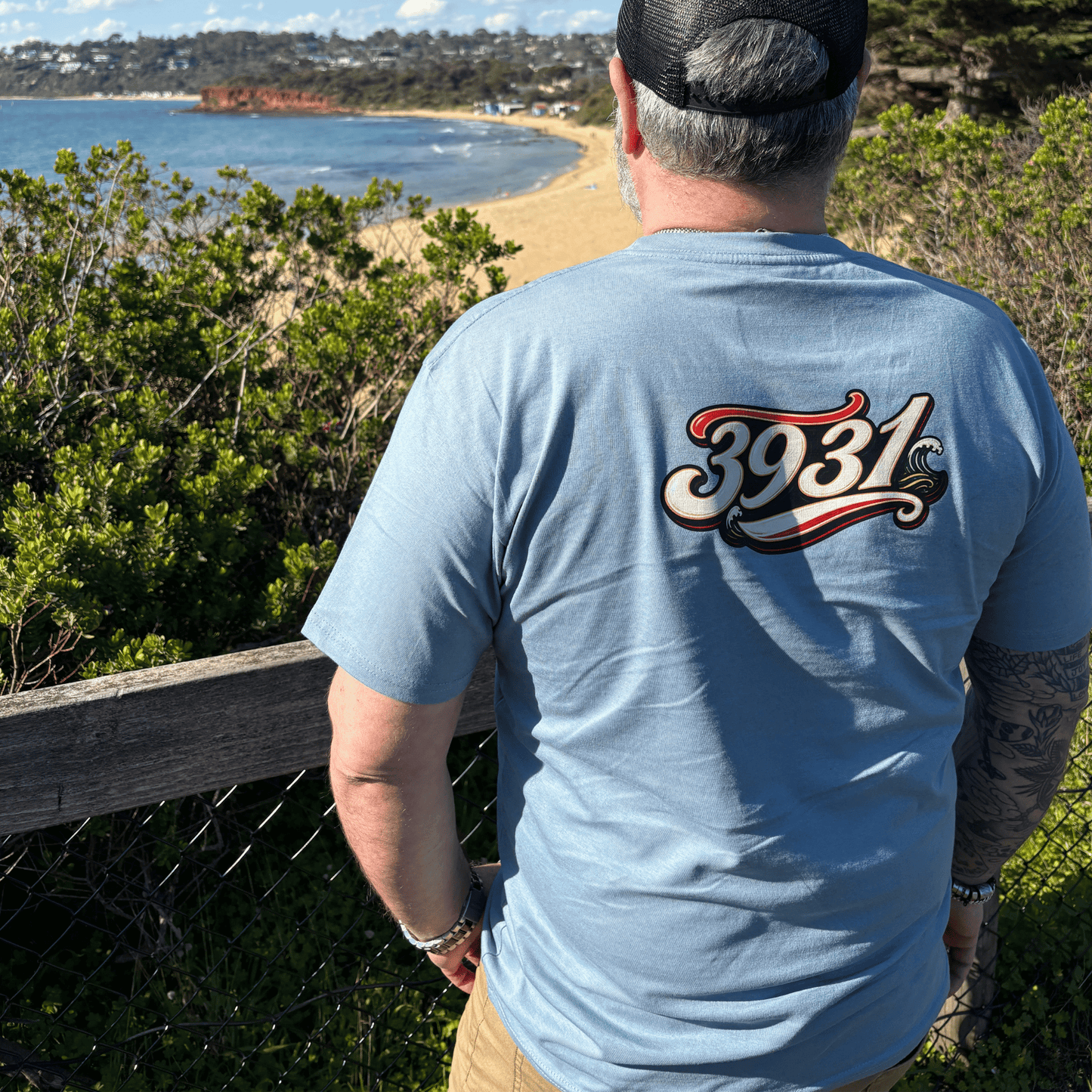 Rear view of The Ninch dusty blue tee displaying the example 3931 Mornington Peninsula postcode graphic