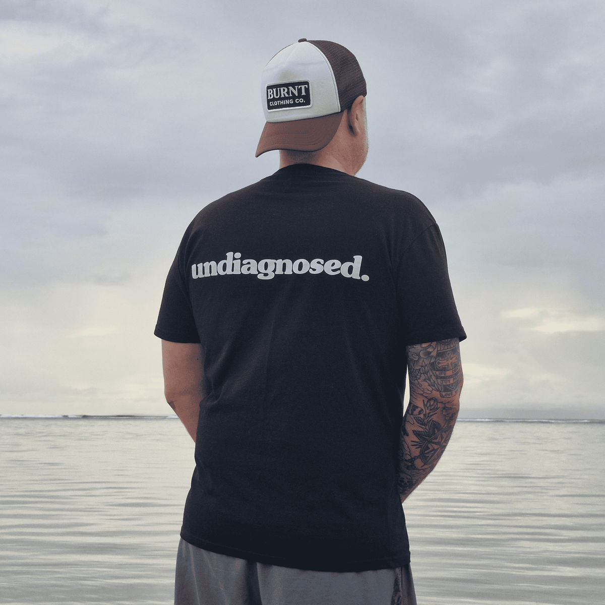 Back view of black undiagnosed. t-shirt with white statement print.