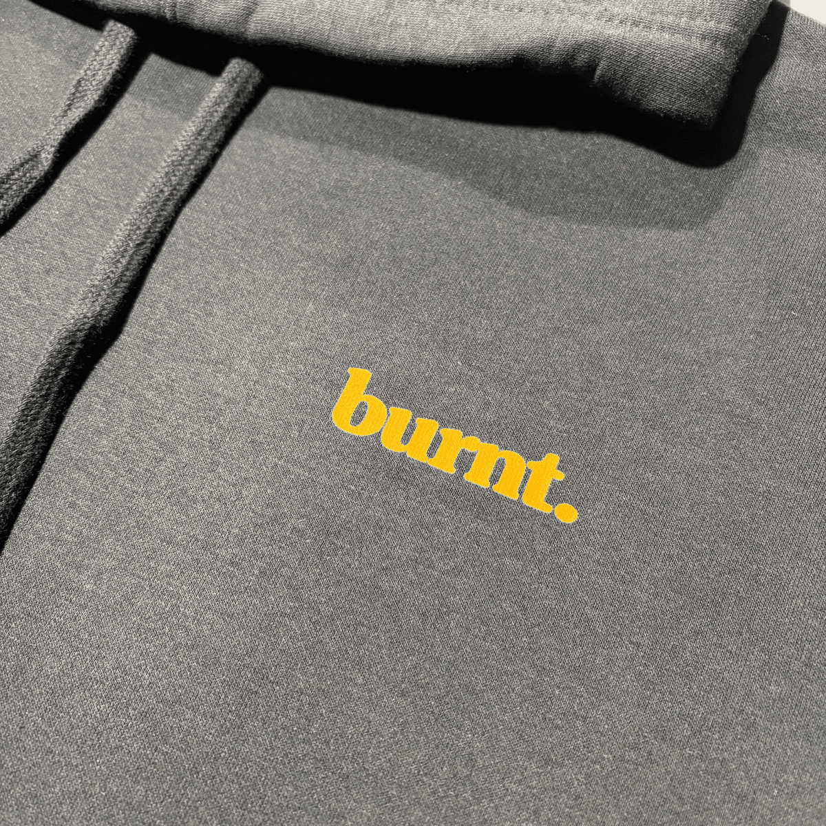 Close-up of the small burnt. logo printed inside the black hoodie