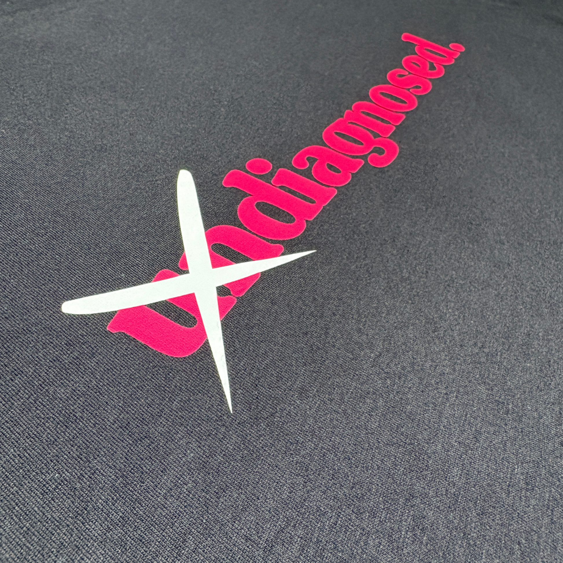 Pink diagnosed. logo detail on black hoodie fabric