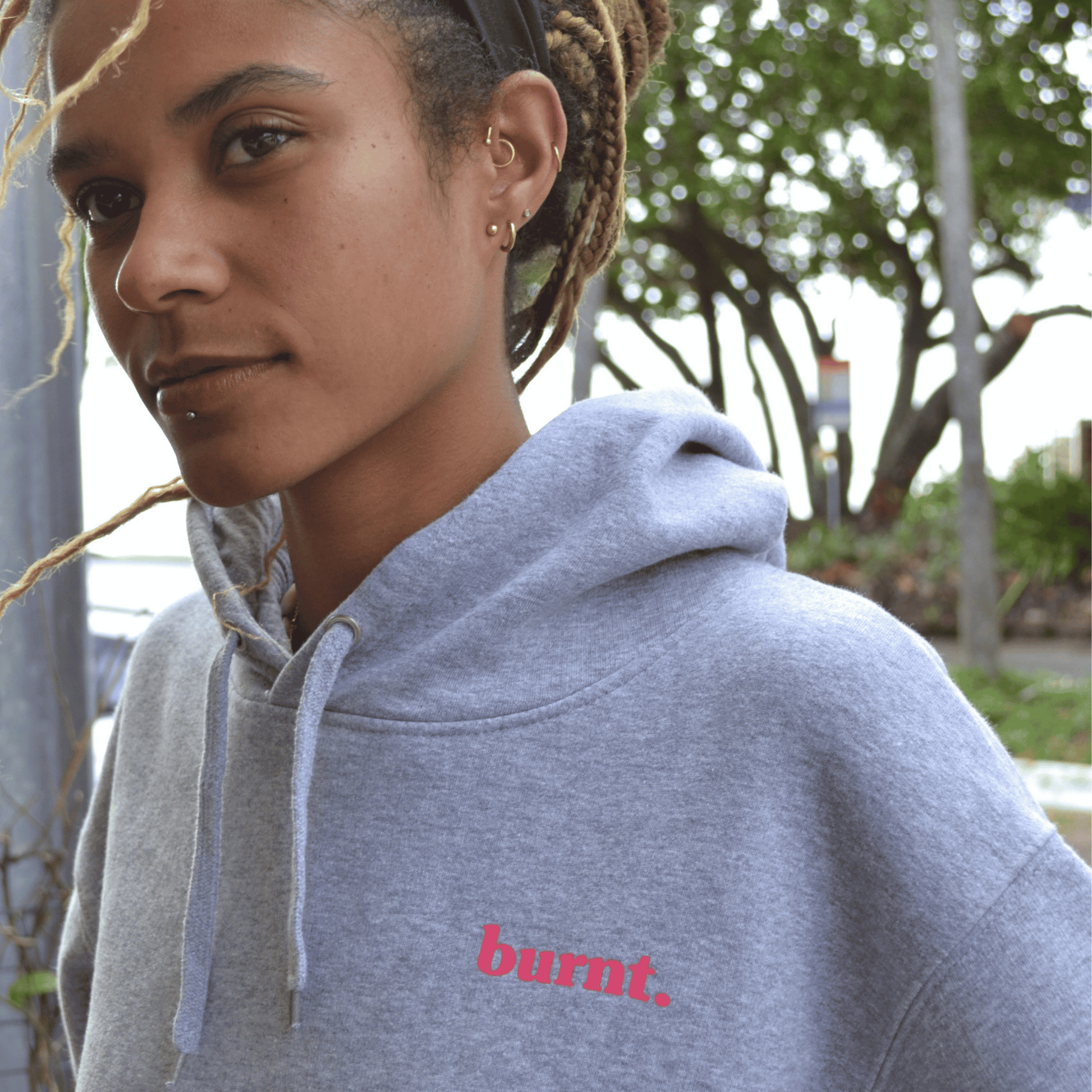 Close-up of diagnosed. grey hoodie with pink chest logo