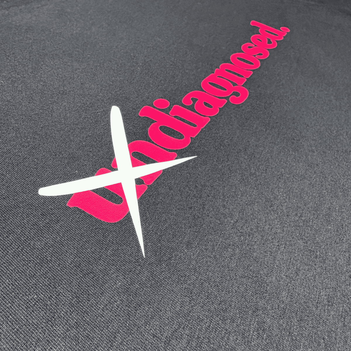 Black diagnosed. limited edition tee with pink front print and crossed-out white un detail by Burnt Clothing Co.