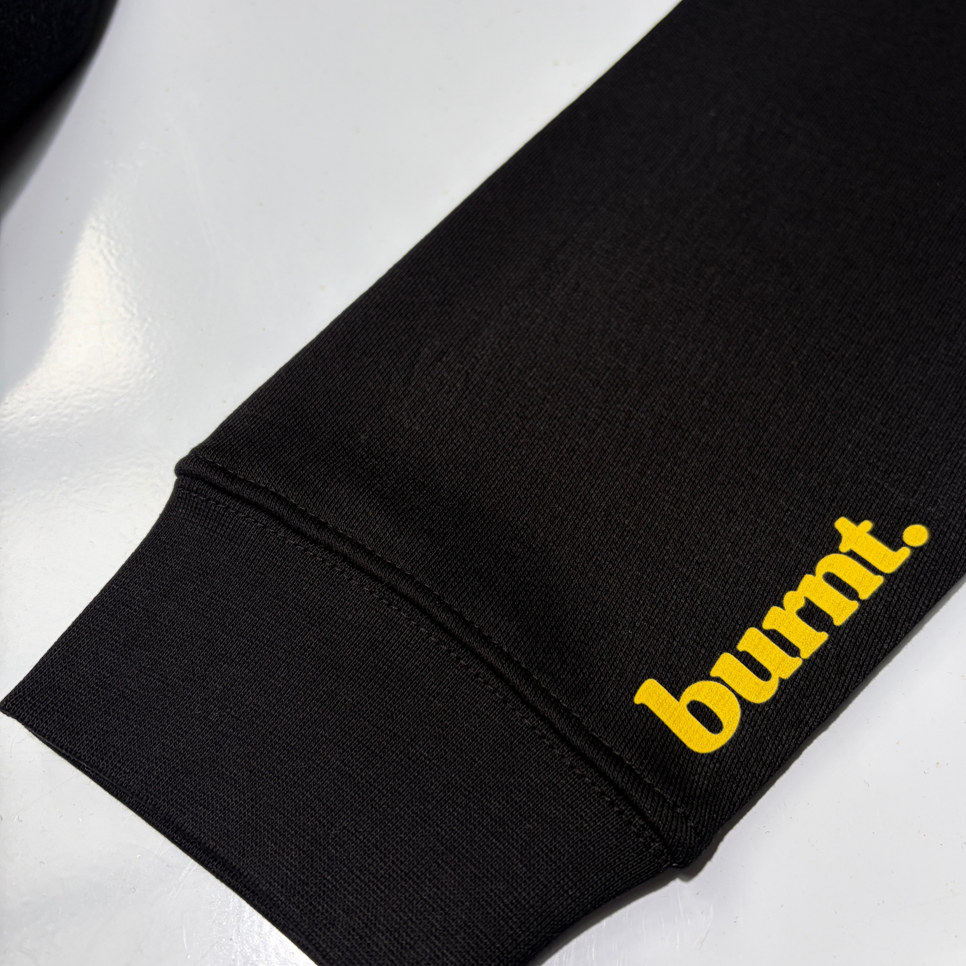 Burnt Clothing Co. yellow sleeve print on black overstimulated. hoodie