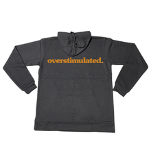 Black overstimulated. hoodie with burnt orange front print, shown flat.