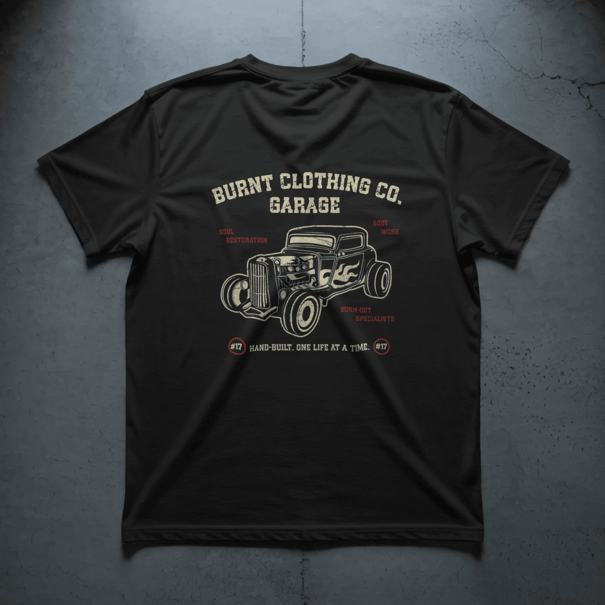 Flatlay of Burnt Soul Restoration Garage black t-shirt featuring vintage hot rod back graphic