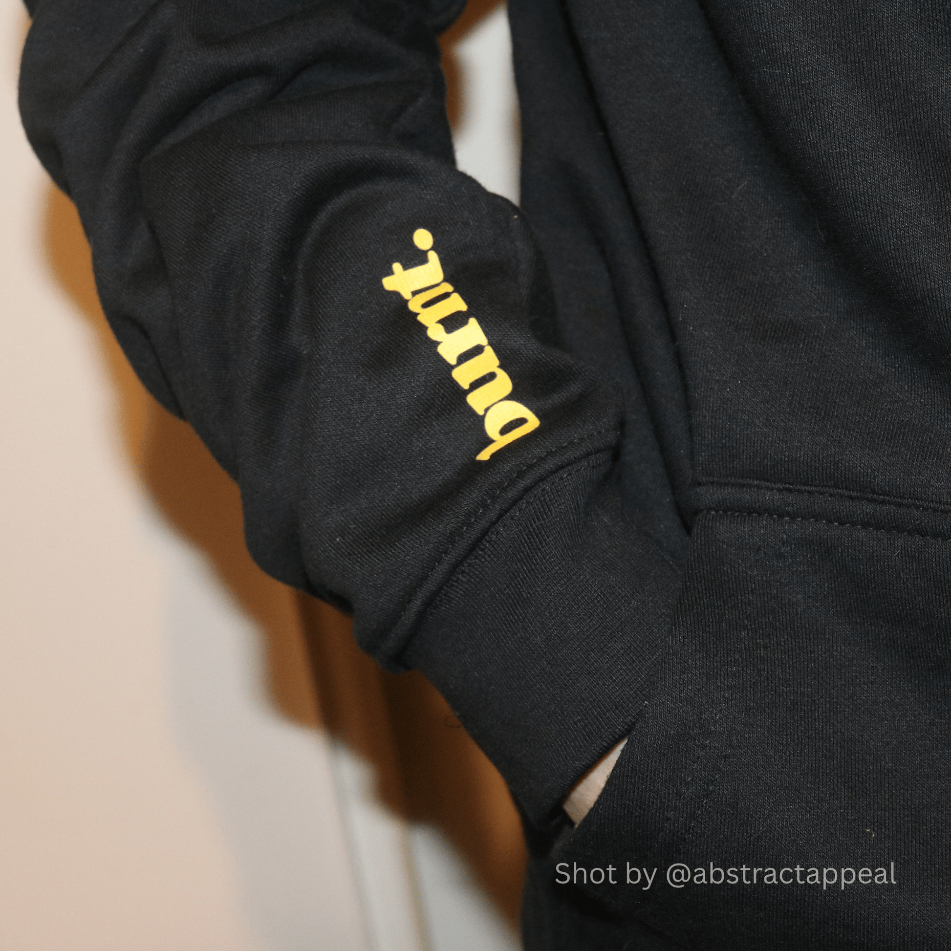 Yellow Burnt sleeve print on the undiagnosed. black hoodie