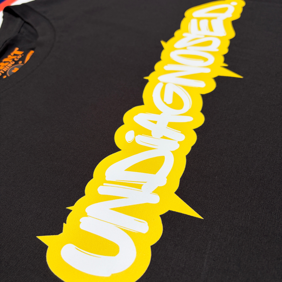Yellow and white undiagnosed. front print detail on black cotton tee