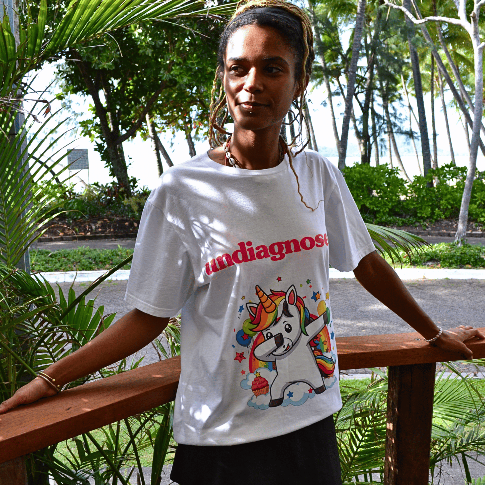 Model wearing undiagnosed. Unicorn white graphic tee by Burnt Clothing Co